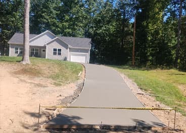 Freshly poured concrete driveway leading up a hill to a residential home in Middle Tennessee