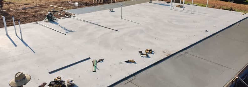 Large commercial concrete slab with steel post anchors poured for a metal building in Tennessee