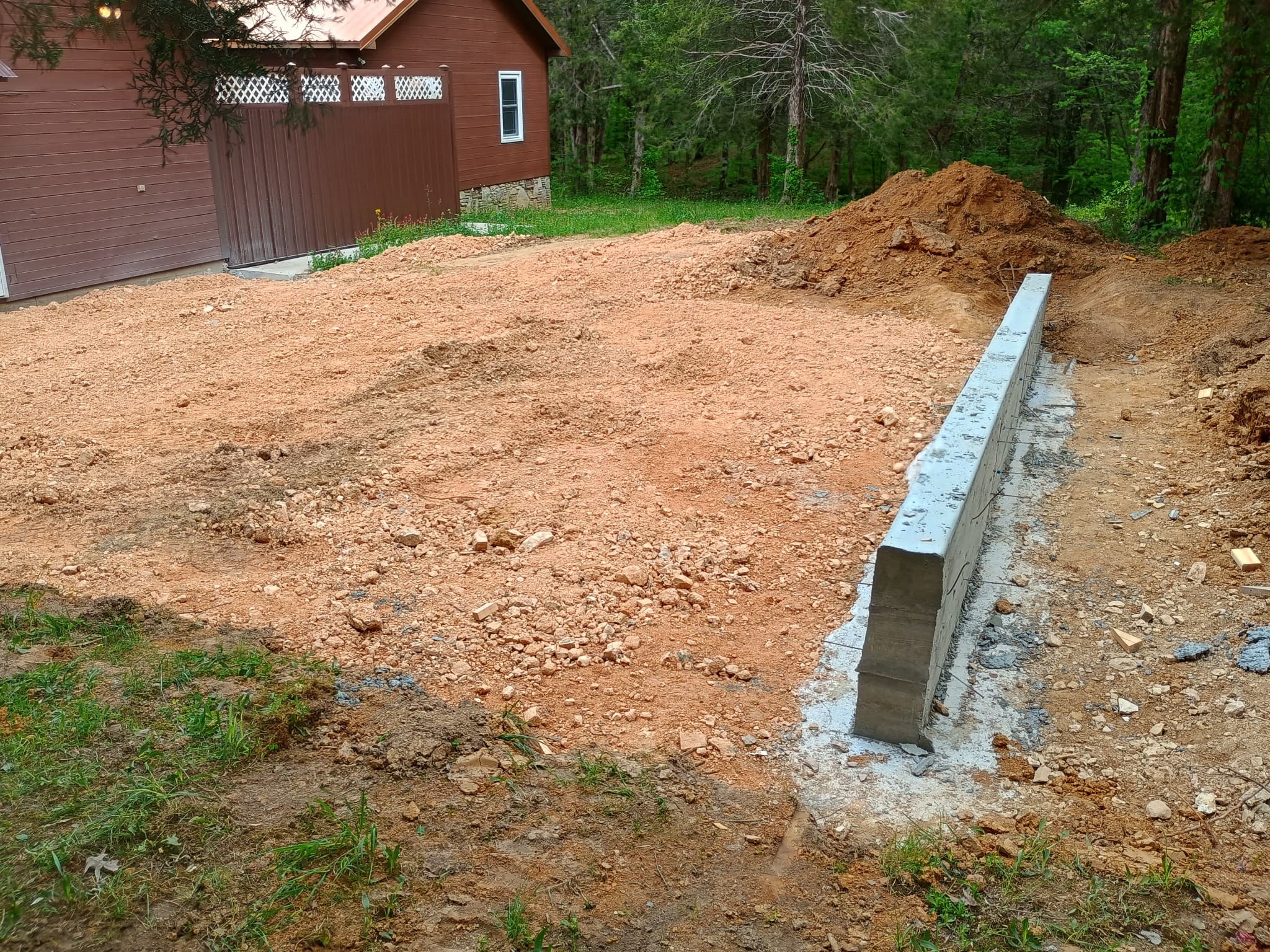 Concrete retaining wall and foundation work for a new building site with Tennessee red clay soil